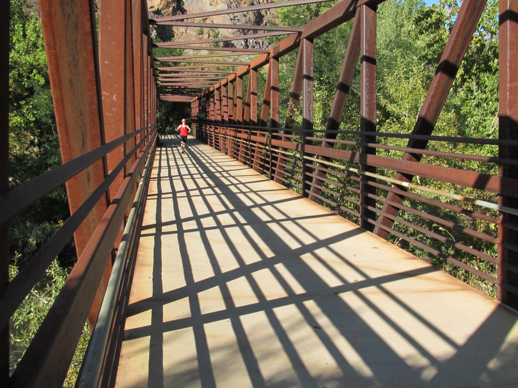 Robyn leaving the Clear Creek Trail to cross the bridge, grab our climbing gear and jog up to the crag!